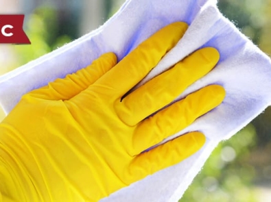 hands in yellow rubber gloves holding a cleaning cloth