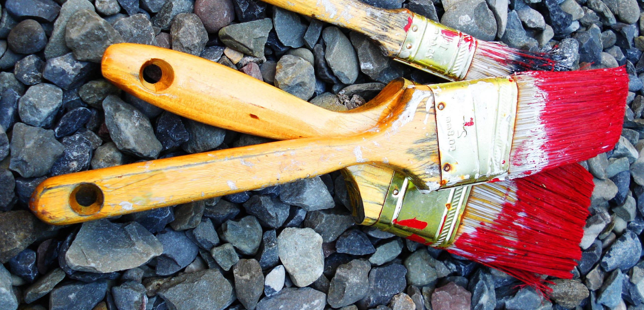 three paint brushes with red paint on them