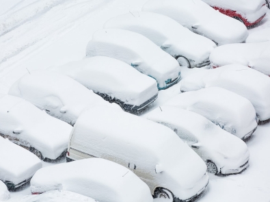 cars in a parking lot covered in snow