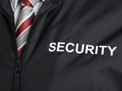 a man wearing a black jacket with the word "SECURITY" printed on it