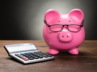 pink piggy bank next to calculator