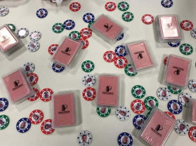 poker chips and decks of cards with the Planned Companies logo on the back of the cards