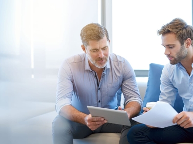 two businessmen discussing something displayed on an ipad