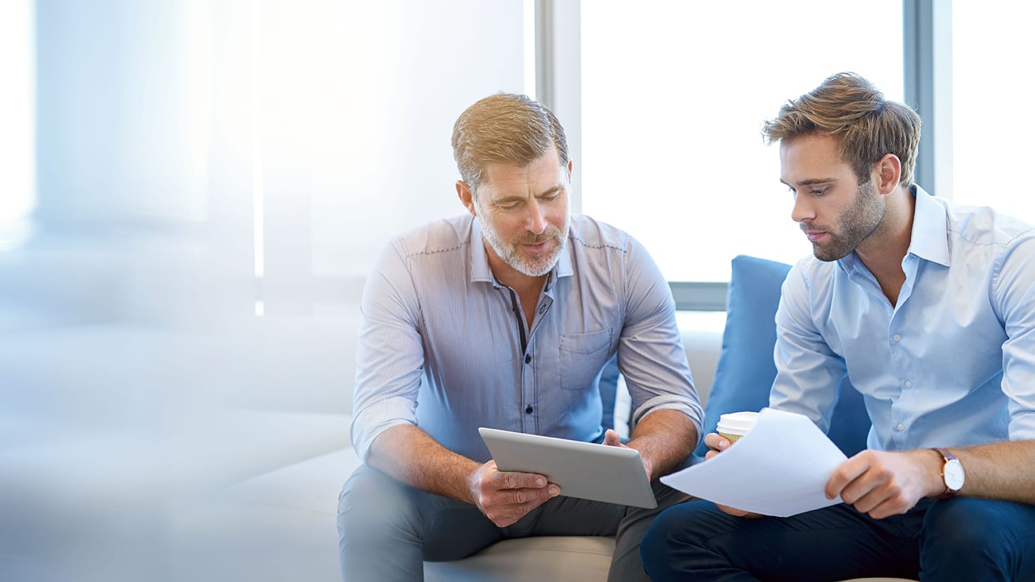 two businessmen discussing something displayed on an ipad