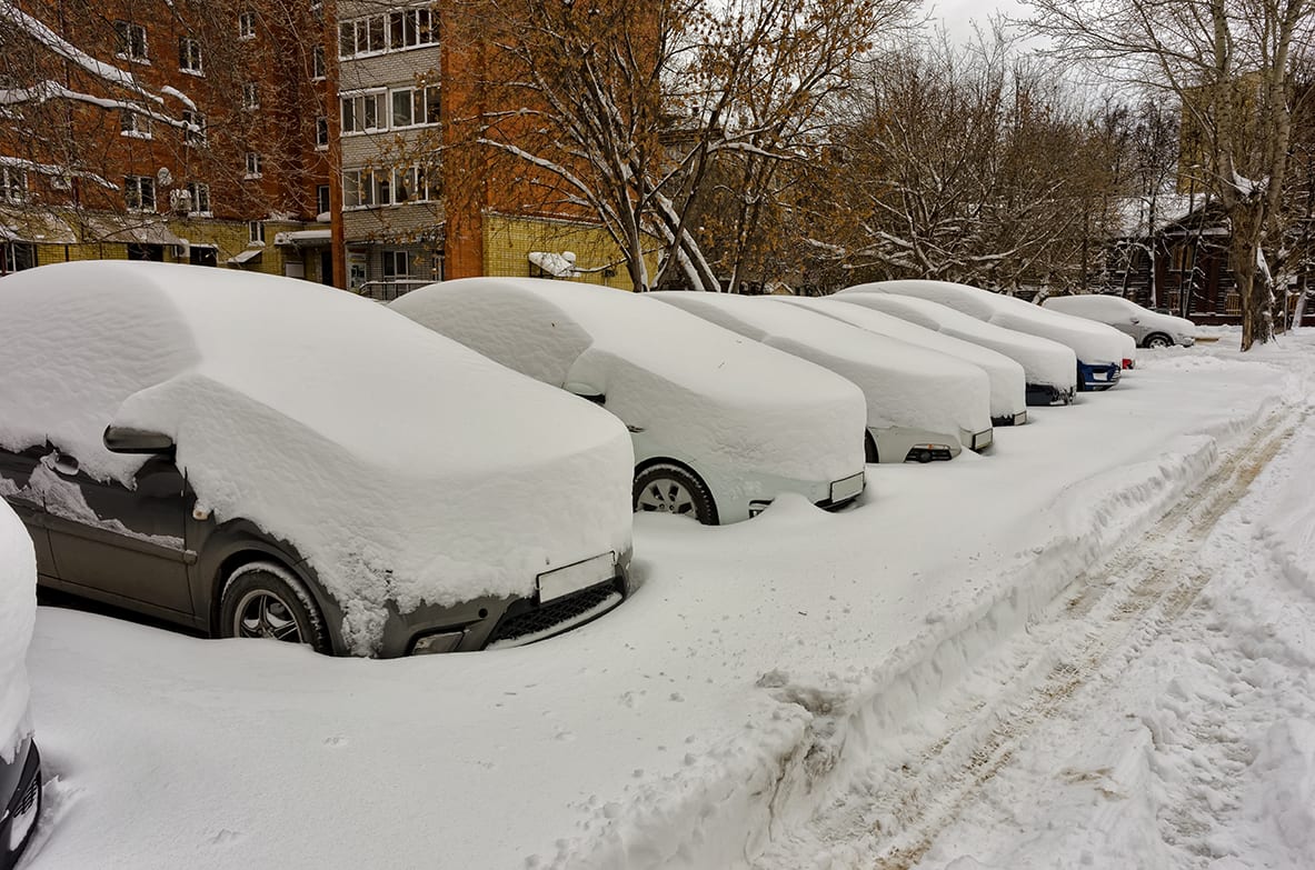 cars covered in snow in a parking lot