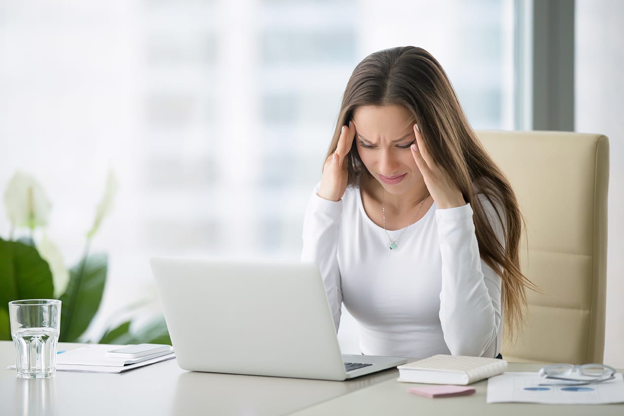 a woman with a headache holding her temples