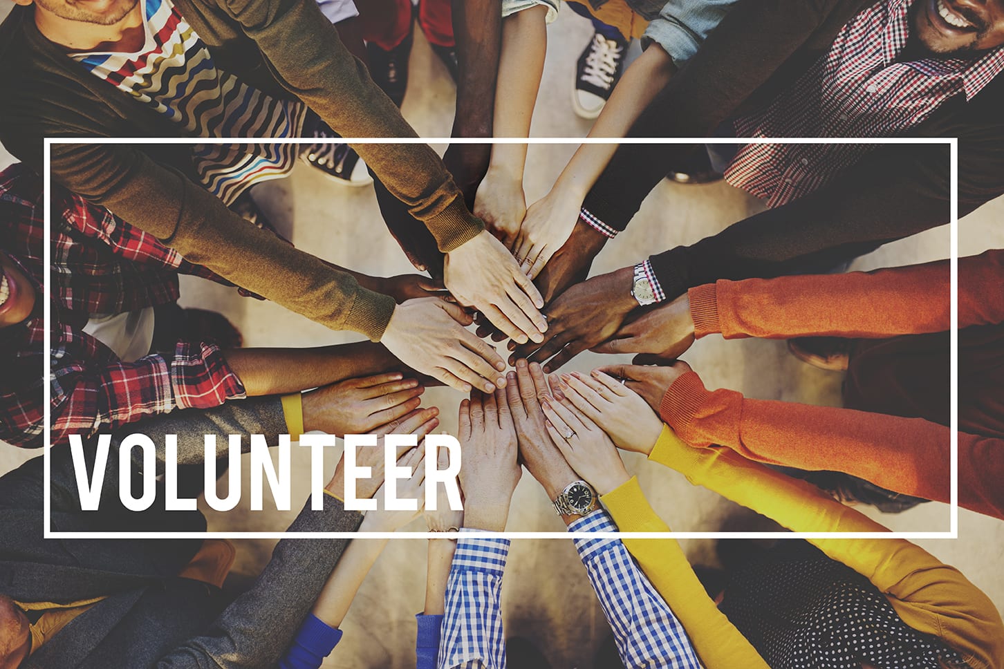 a group with their hands in a circle with the word "Volunteer" on it