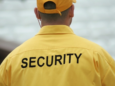 a man wearing a jacket with "security" on the back of it