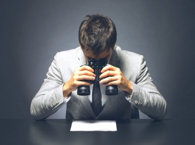 a businessman looking at a contract with binoculars