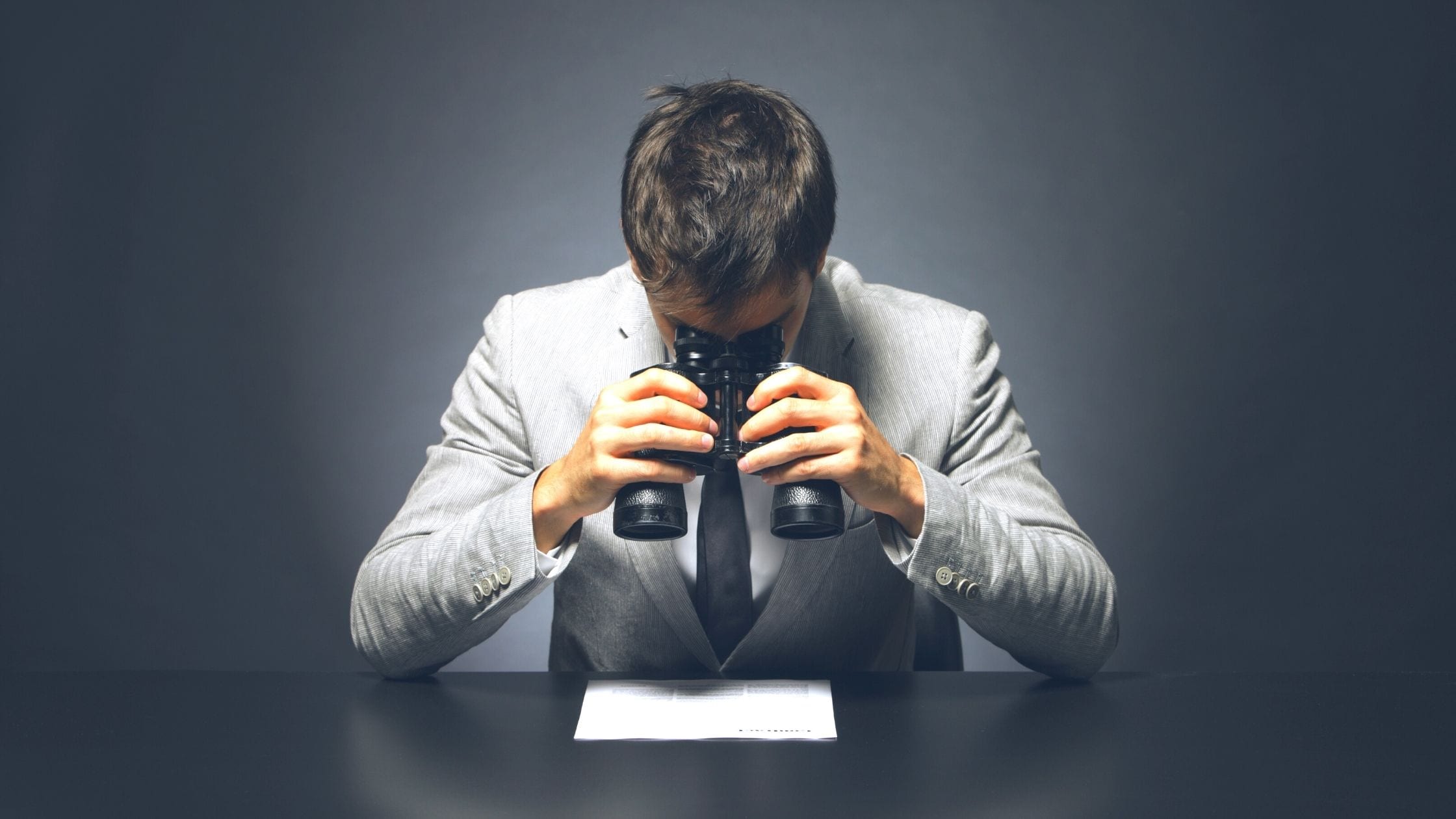 a businessman looking at a contract with binoculars