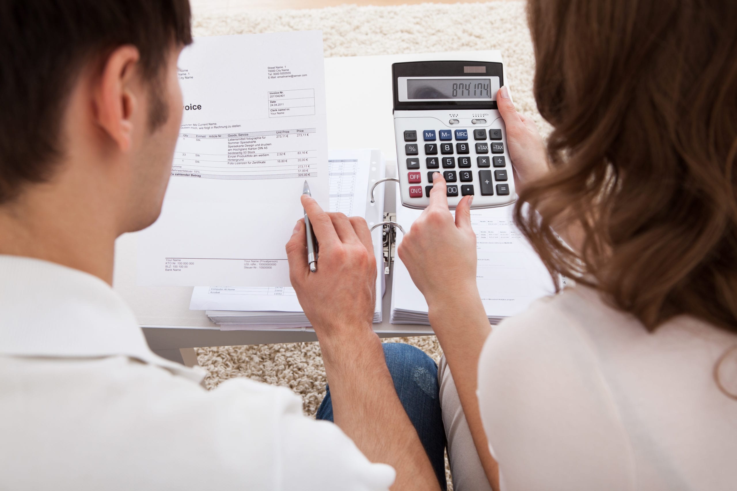 a couple reviewing an invoice with a calculator