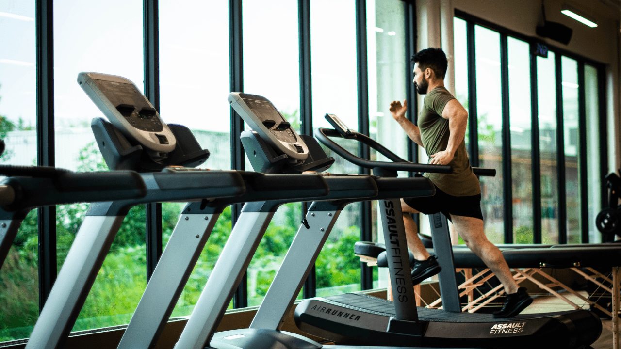 a man running on a treadmill in a gym