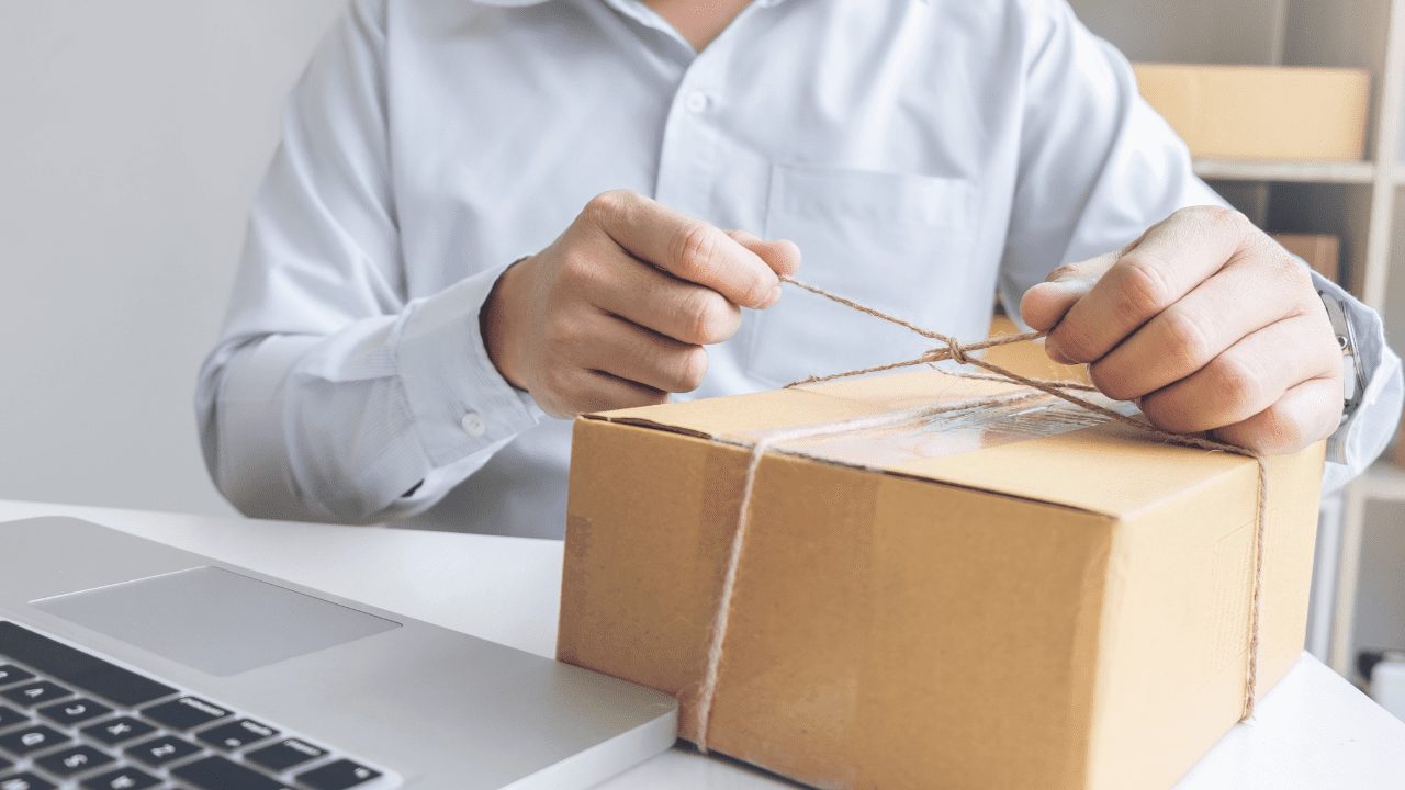 a man tying a string around a box