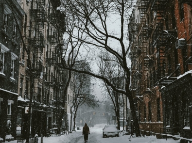 a snowy street with apartments on both sides