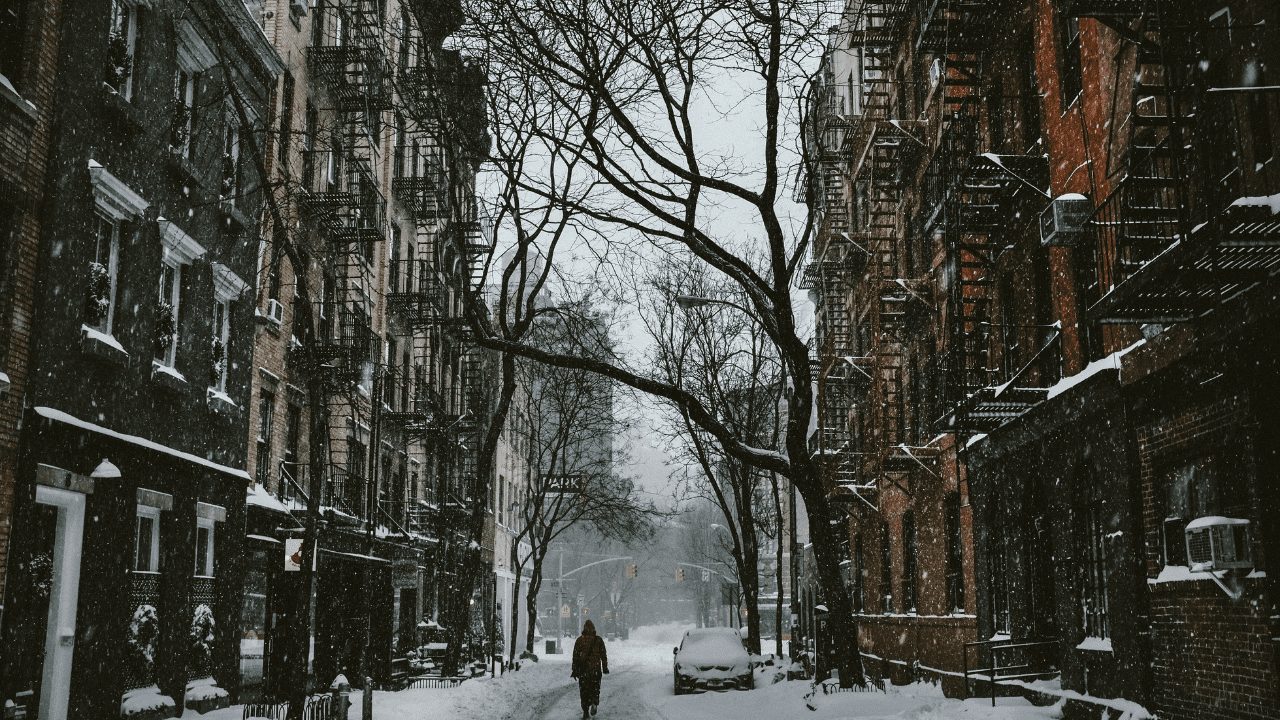 a snowy street with apartments on both sides