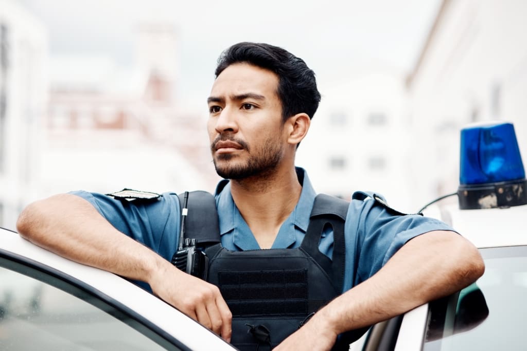 Police, thinking and man officer by a car for an investigation or patrol for law protection in city